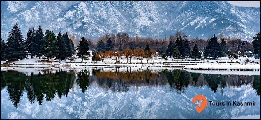 Mountain covered in snow with Dal lake in front